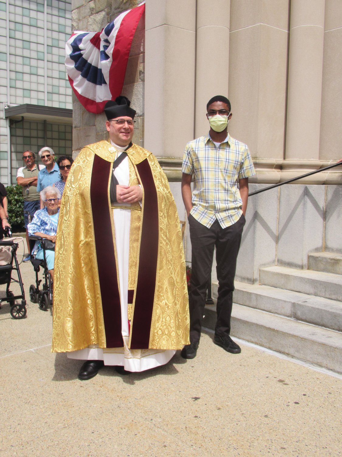 POPULAR PASTOR: Rev. Angelo N. Carusi is joined by a Saint Rocco’s parishioner prior to Sunday’s annual feast and festival procession.